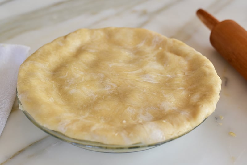 Pie crust on top of pie before crimping