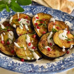 Lebanese eggplant on a blue platter with tahini sauce