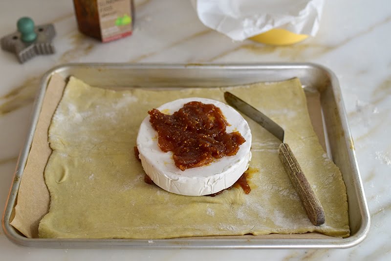 Fig jam spread on a wheel of brie on puff pastry