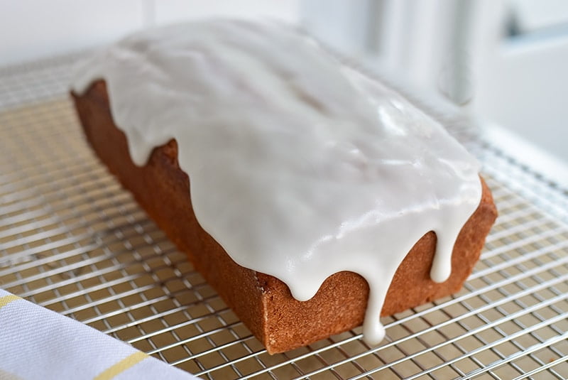 Olive oil loaf cake with white glaze dripping down the side