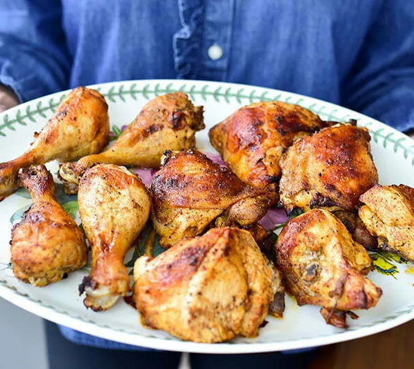 7 Spice chicken on a platter held in hands