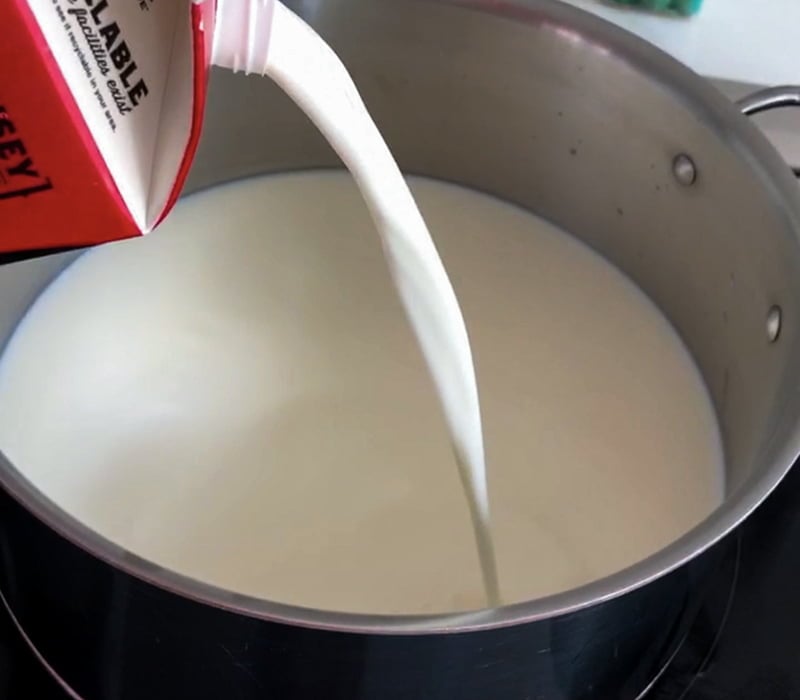 Whole milk pouring into a pan for homemade yogurt