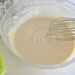 Tahini sauce in a bowl with a whisk
