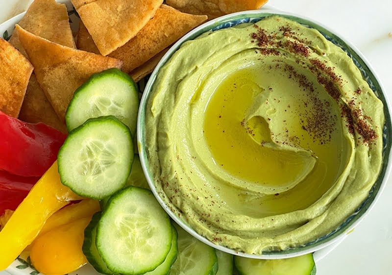 Avocado hummus with olive oil and sumac in a round dish