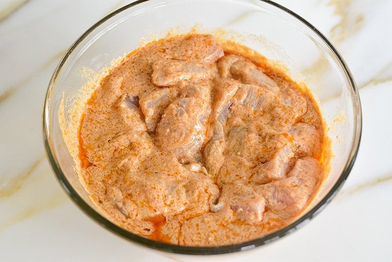 Chicken marinating for Shish Tawook in a bowl.