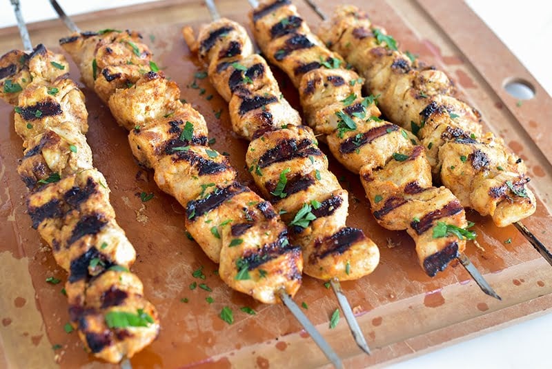 Grilled Shish Tawook on a board.