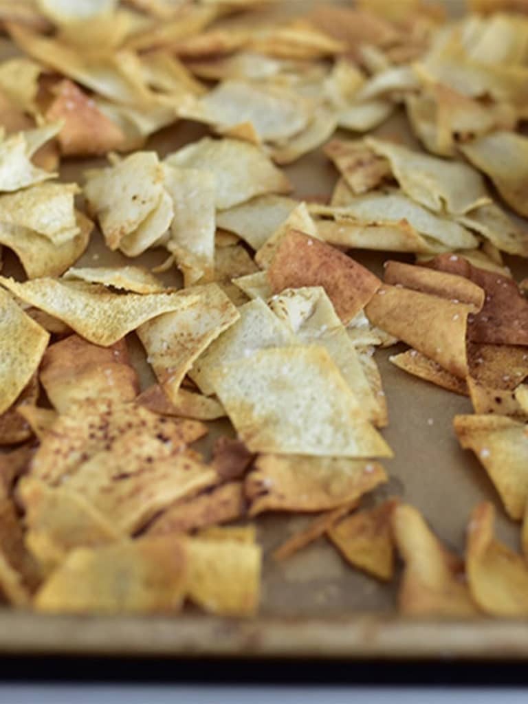 Baked pita chips on a baking sheet. 