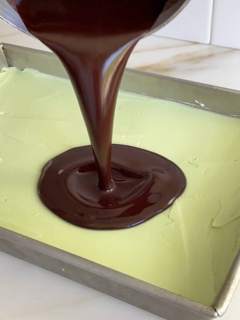 chocolate pouring over green buttercream