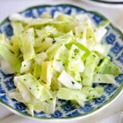 Cabbage salad with garlic and lemon on a blue plate