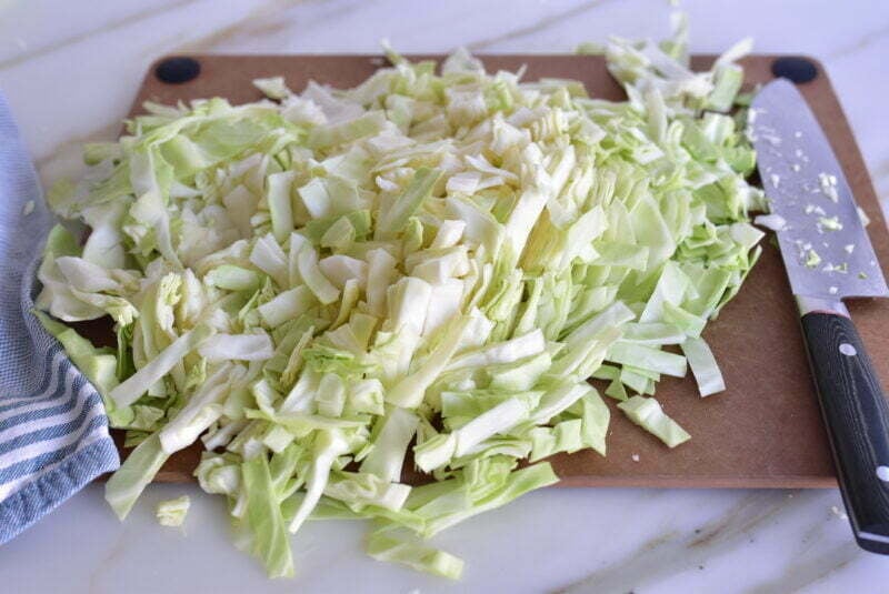 Shredded cored cabbage on a board