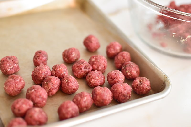 Meatballs formed by hand on a sheetpan