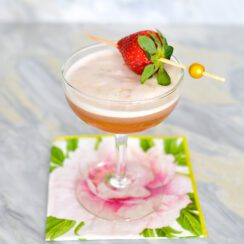 Strawberry cocktail with jam and gin in a coupe with a strawberry pick
