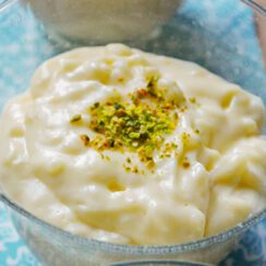 Rice pudding with pistachios on top in a bowl