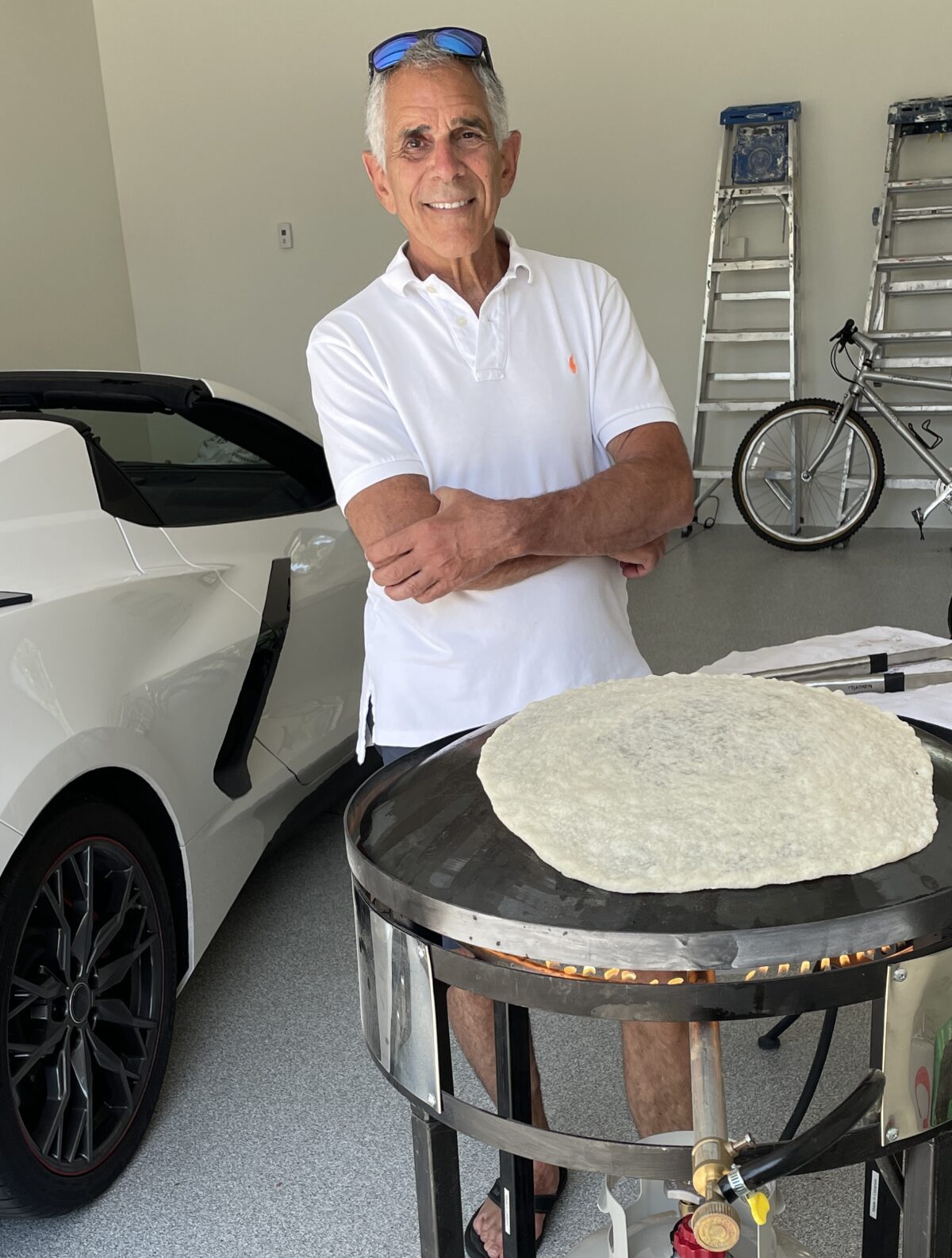 Maureen Abood's husband baking saj bread on a saj dome oven