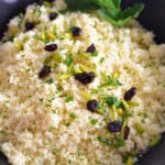 Couscous in a black dish with herbs and nuts