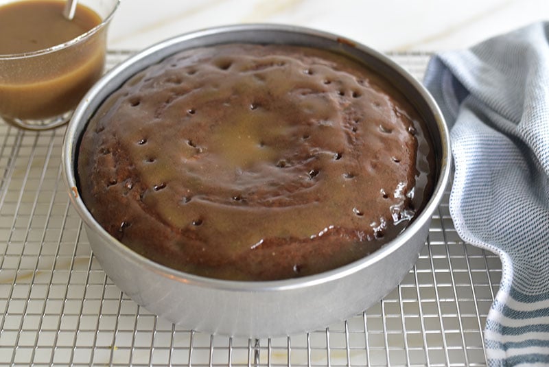Sticky date cake in the pan with glossy caramel glaze over the top