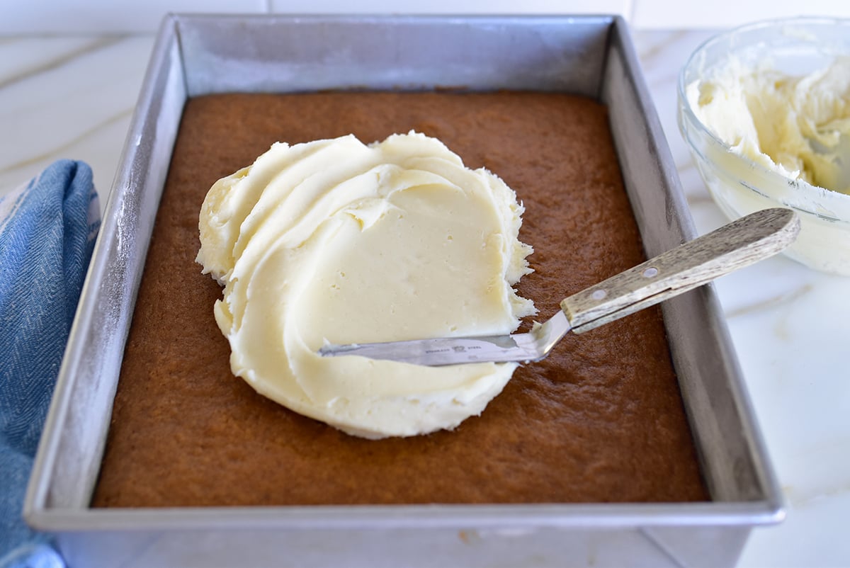 White frosting spread with an offset spatula on cake