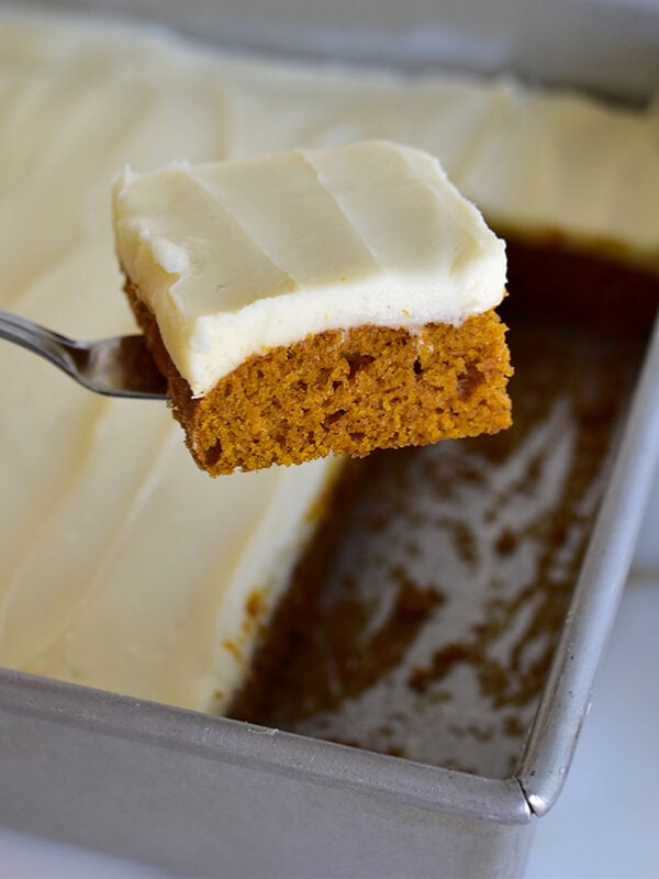 Pumpkin bar slice with white frosting on a serving spatula