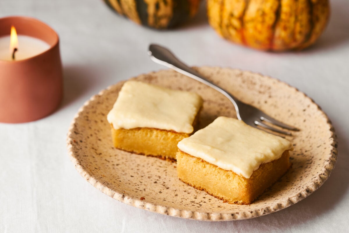 pumpkin bars on a plate with a fork and candle in the background