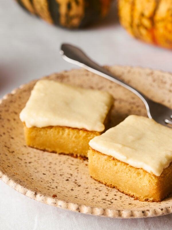 pumpkin bars on a plate with a fork and candle in the background