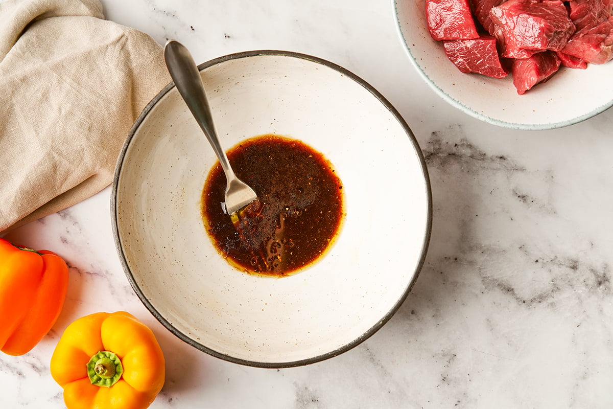 Marinade in a white bowl with a spoon for shish kebab