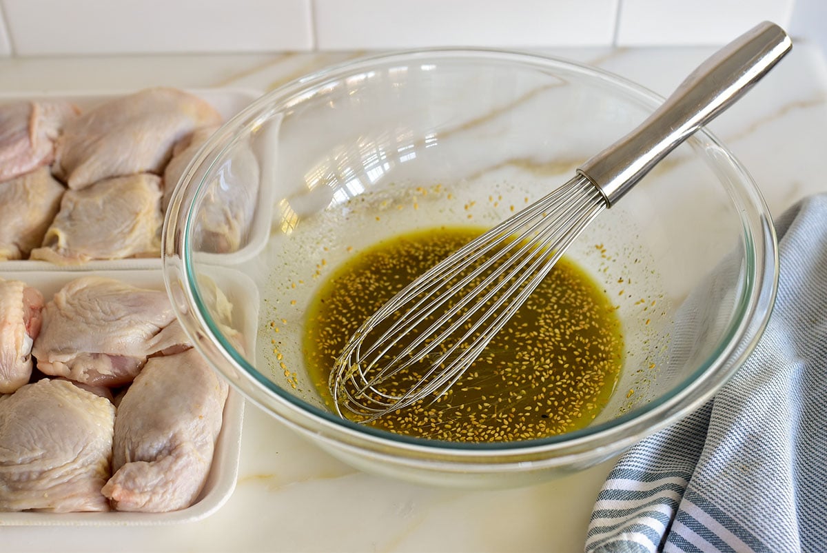 Marinade for chicken in a bowl with a whisk