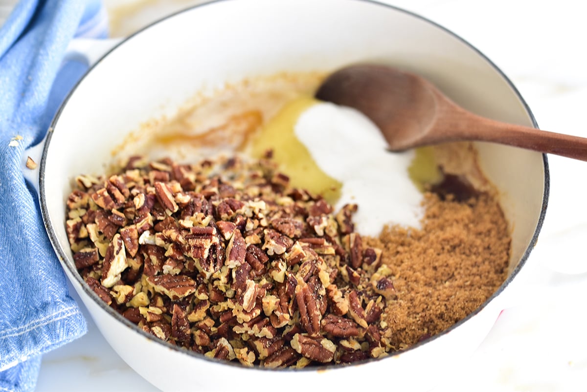 pecans and sugar in a pan with melted butter