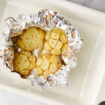 Roasted garlic in foil in a roasting pan