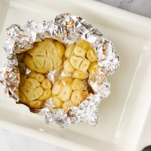 Roasted garlic in foil in a roasting pan