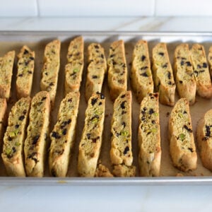 Baked biscotti on a baking sheet on a white counter