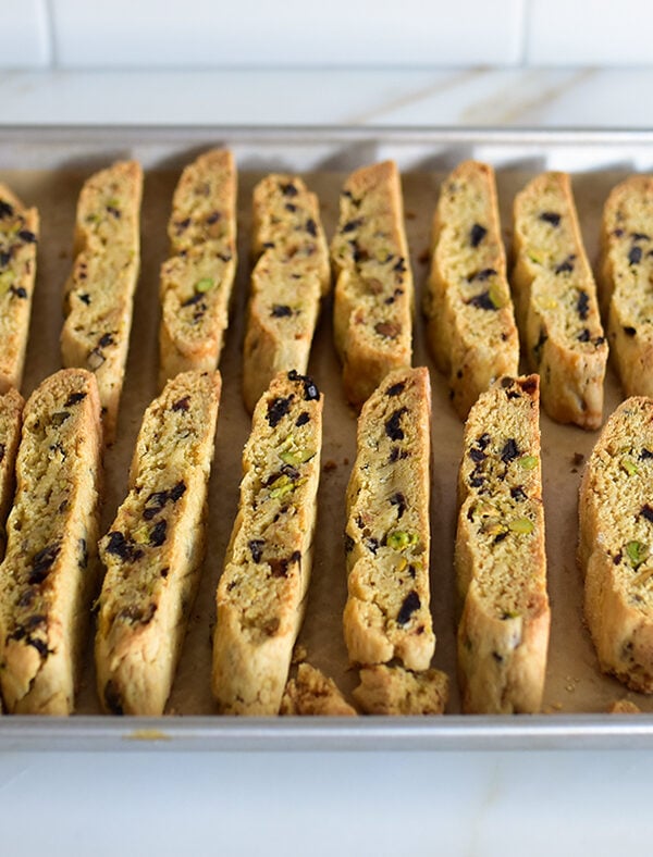 Baked biscotti on a baking sheet on a white counter