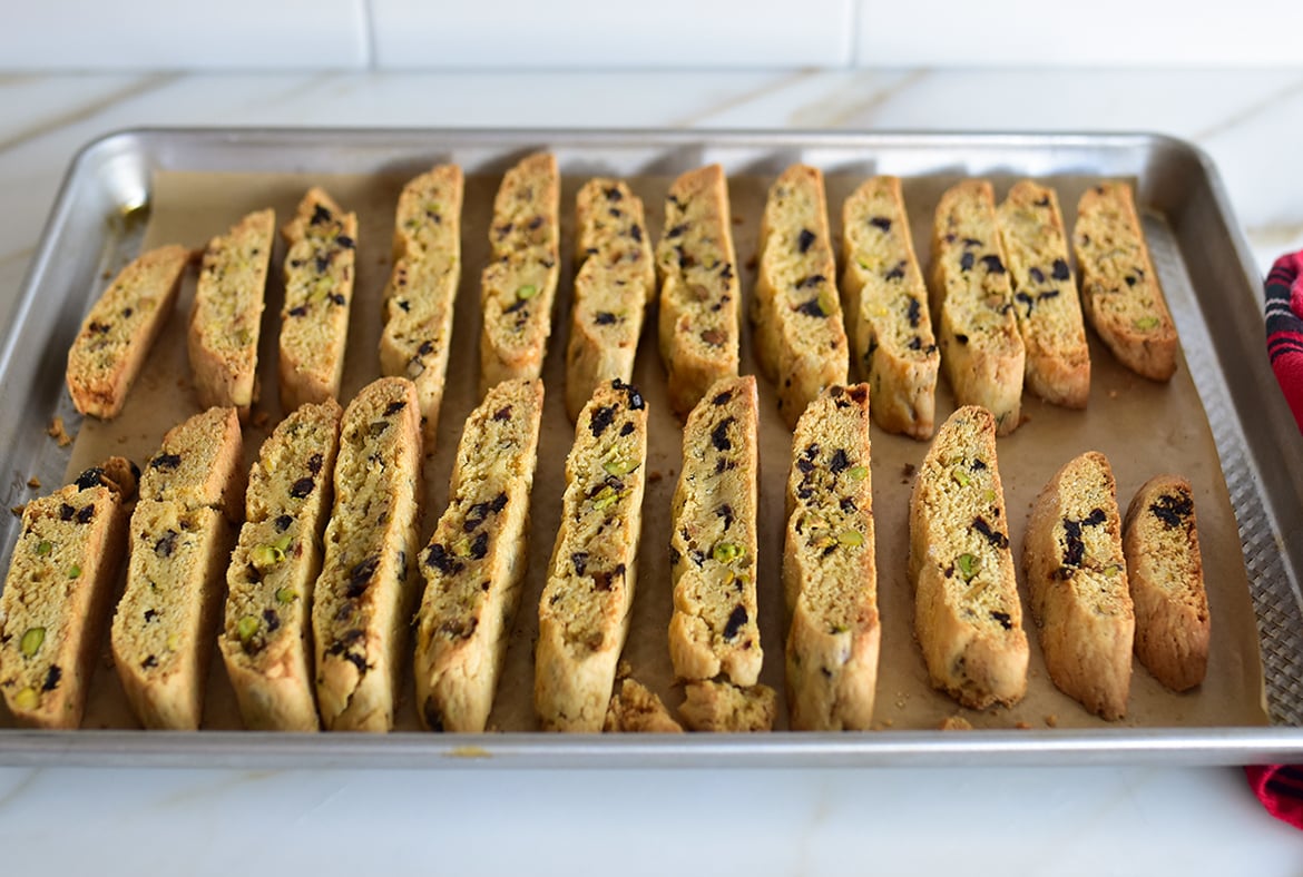 Baked biscotti on a baking sheet on a white counter