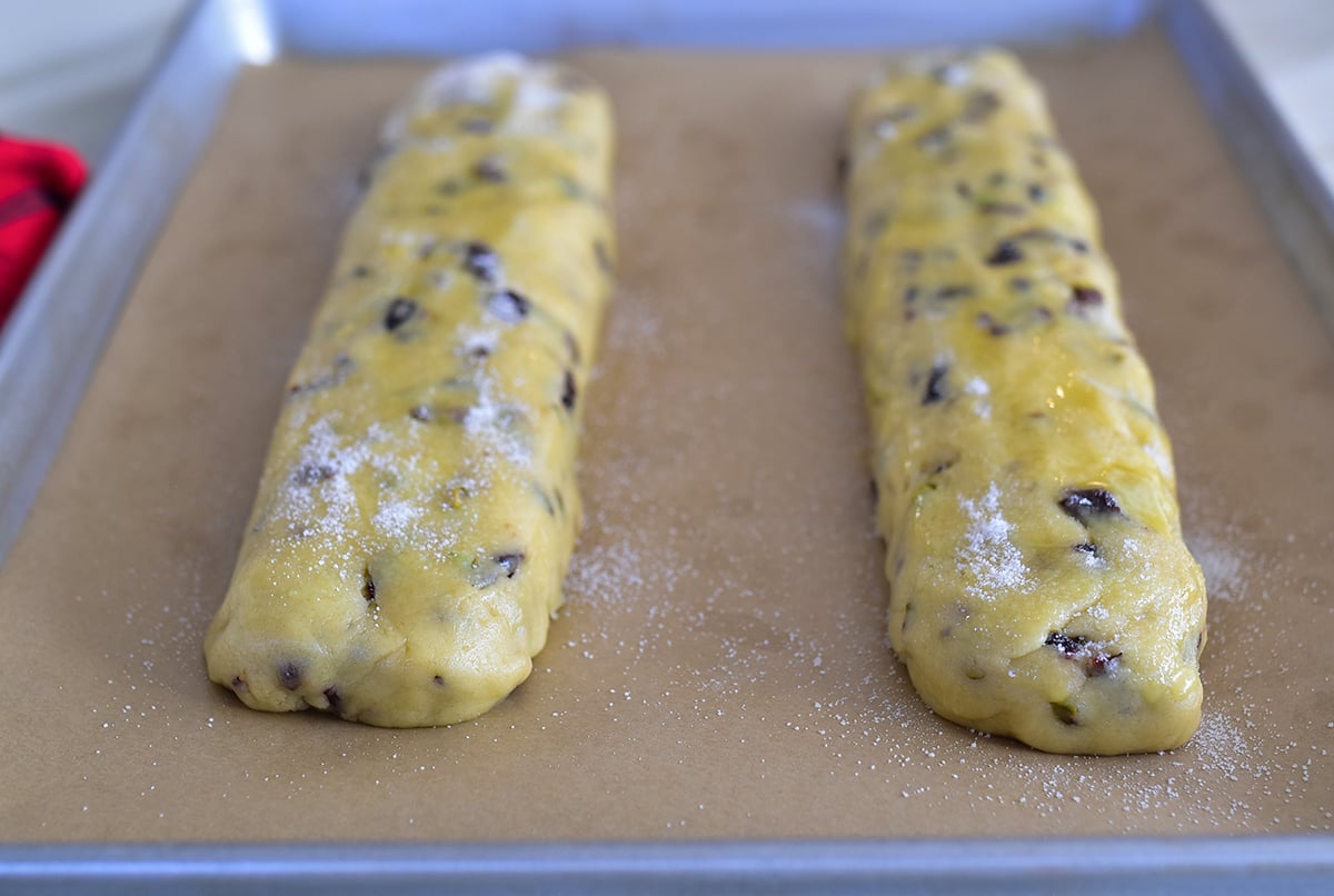 Biscotti dough in logs with sugar and egg wash on a sheet pan