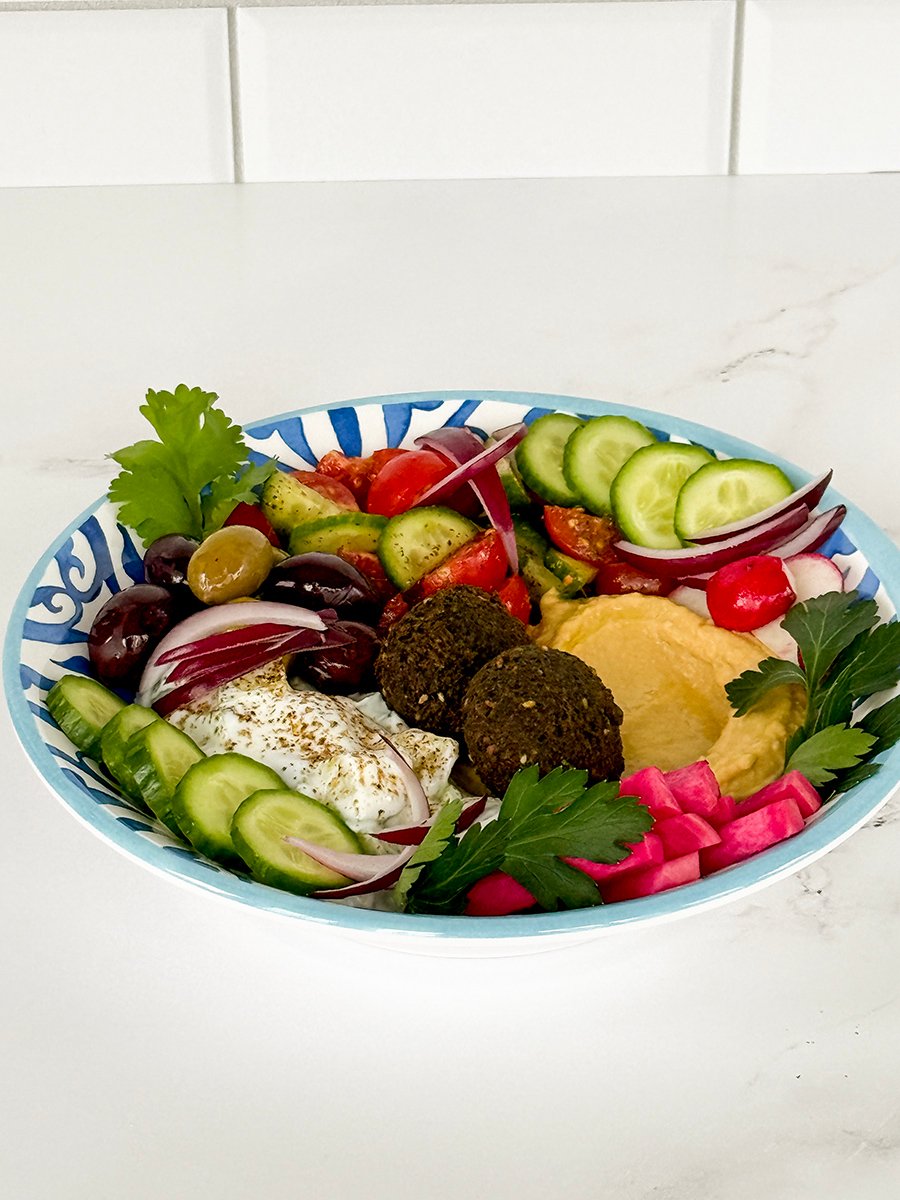 falafel bowl with bright fresh vegetables surrounding several falafel