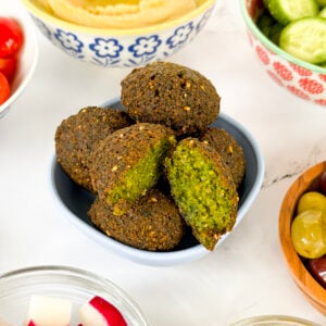 Falafel in a bowl with one cut in half with a bright green center