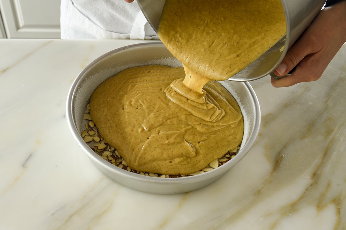 Cake batter for cardamom cake poured into a pan