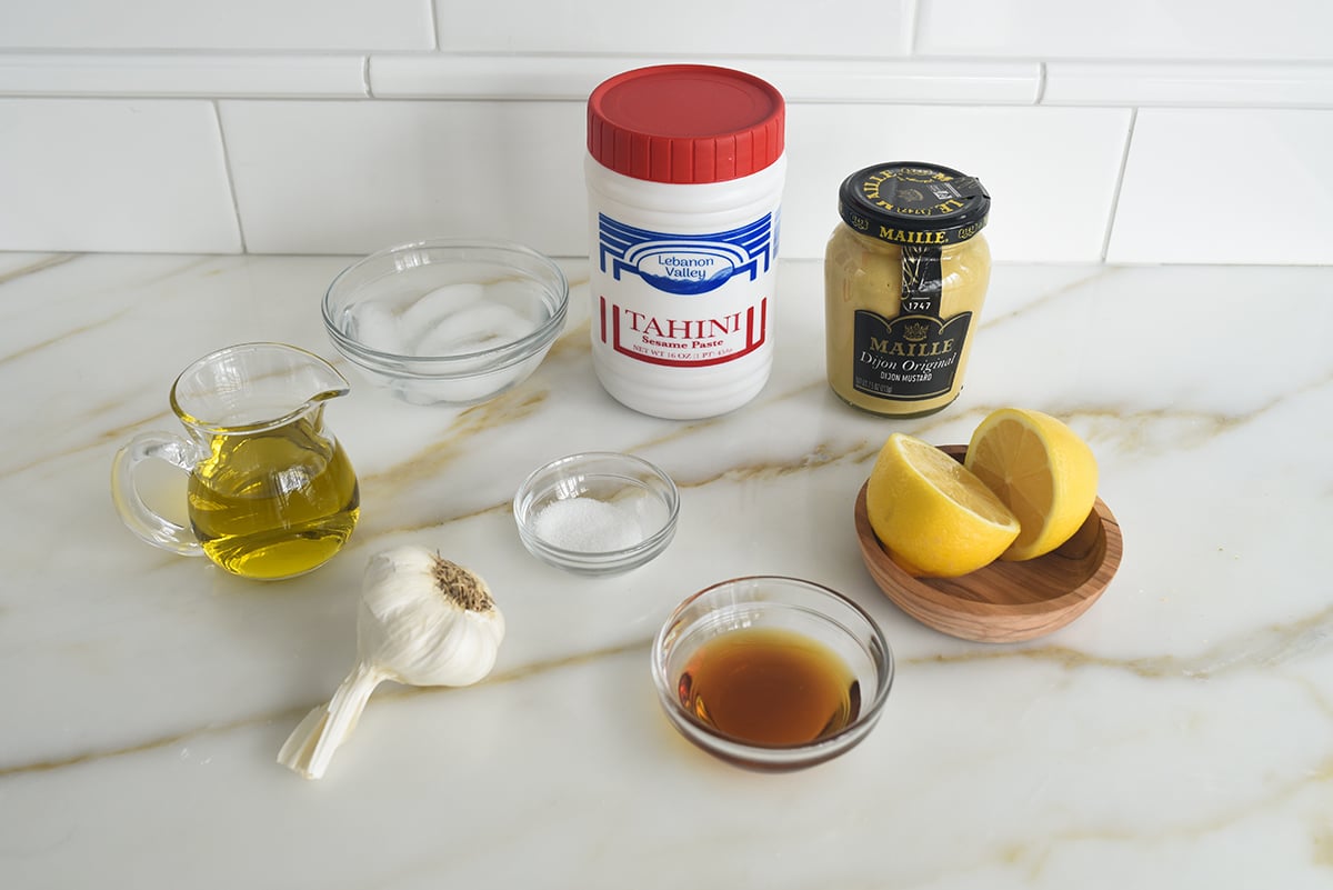 Ingredients for tahini dressing on a marble countertop