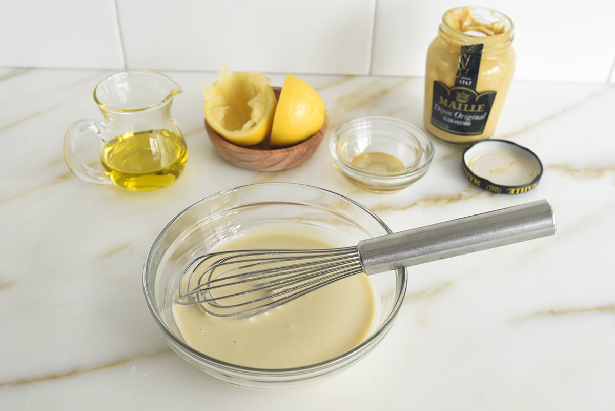 Dressing in a glass bowl with a whisk in it