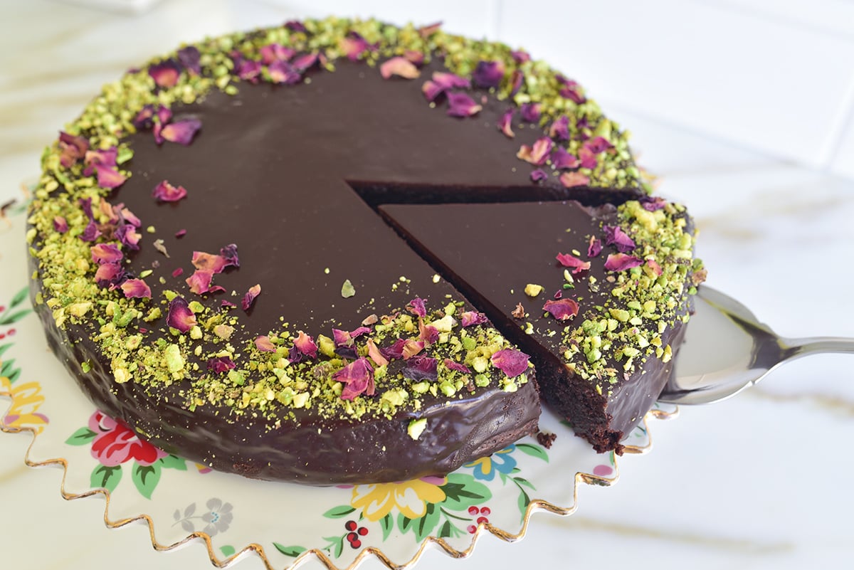 round chocolate cake with a wedge cut out on a pie server
