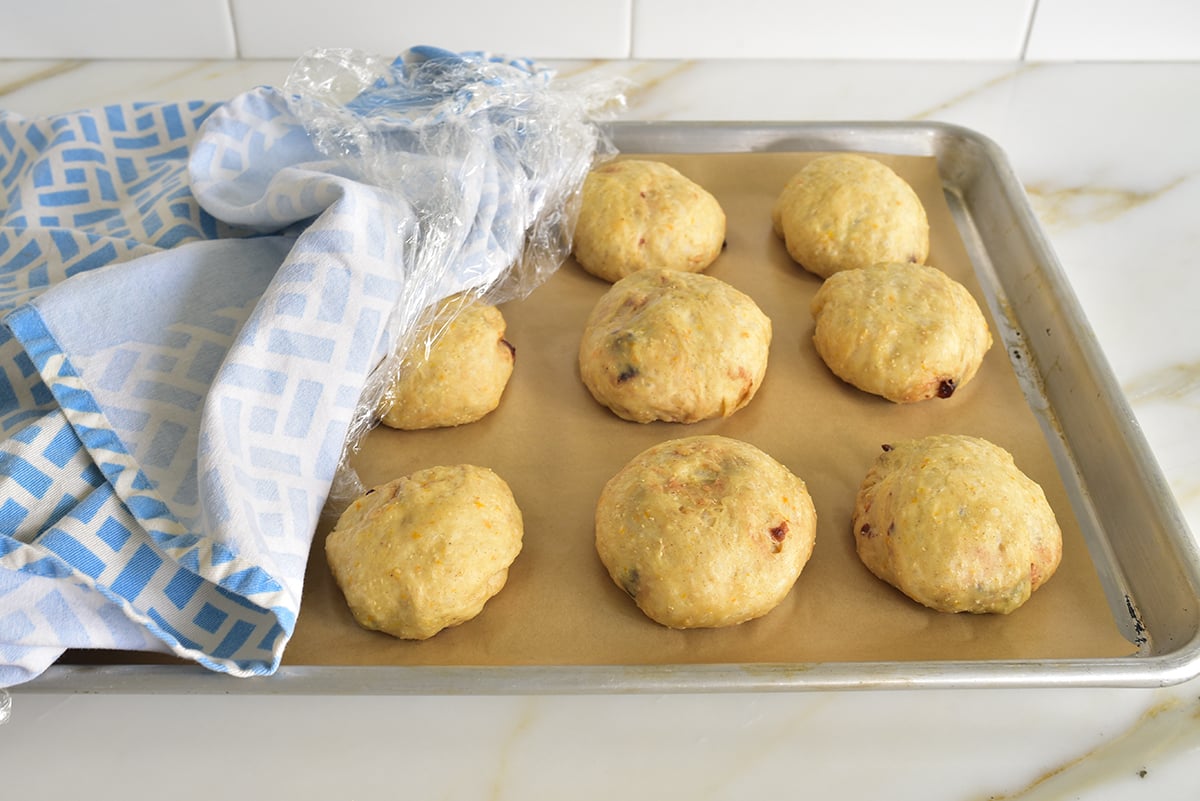 risen dough balls on a parchment lined baking sheet