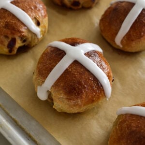 golden brown hot cross bun with a white icing cross on top