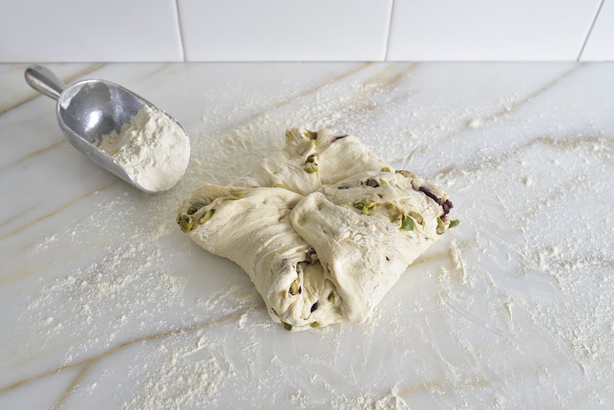 Dough on a marble counter with flour shaped with corners folded