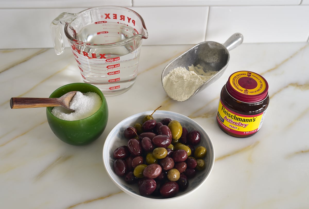 Ingredients for olive bread on a marble countertop