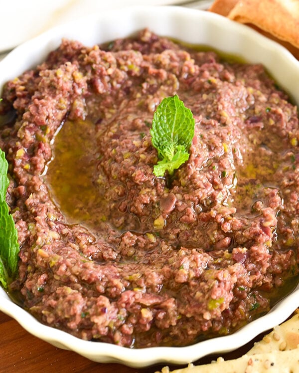 olive tapenade in a white dish drizzled with olive oil