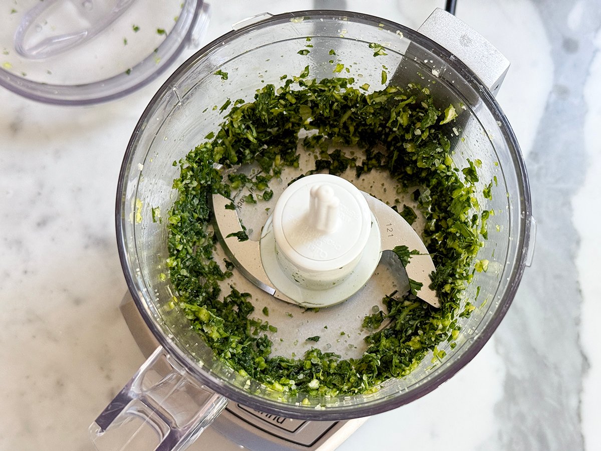 Processor filled with chopped basil and garlic
