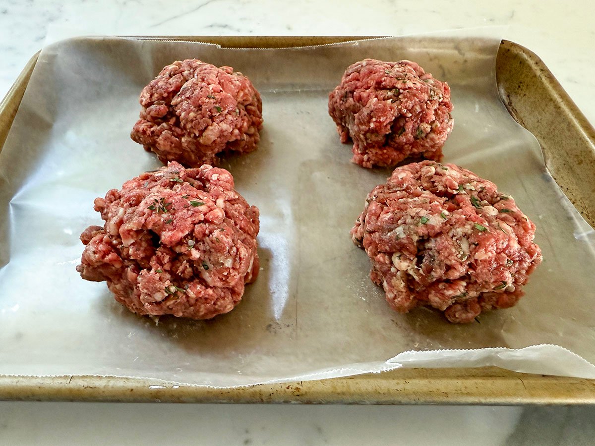 meat shaped into balls on a sheet of wax paper