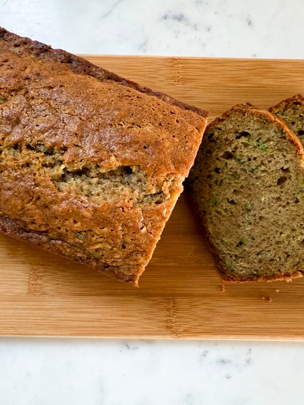Zucchini bread loaf with slices on a wooden board