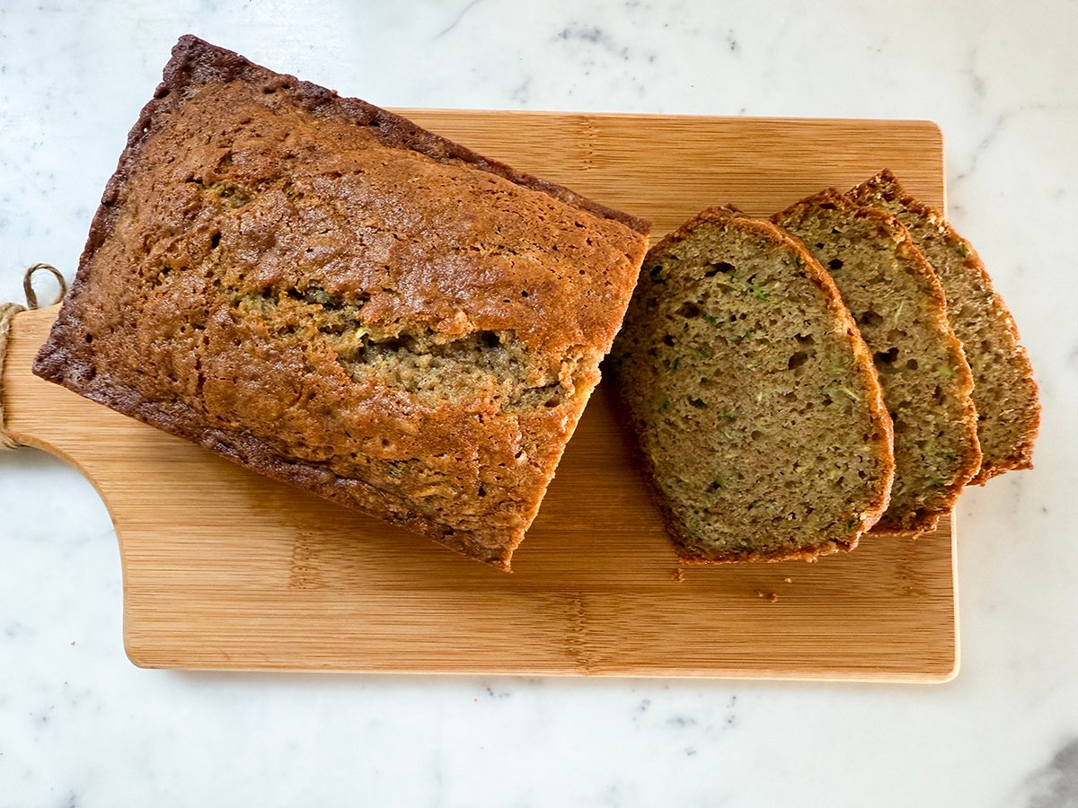 Zucchini bread loaf with slices on a wooden board