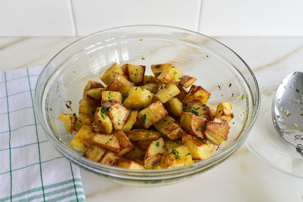 Cubes of roasted potatoes in a glass bowl