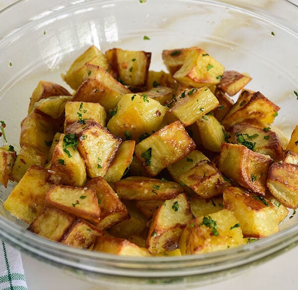 spicy lebanese potatoes flecked with cilantro in a bowl